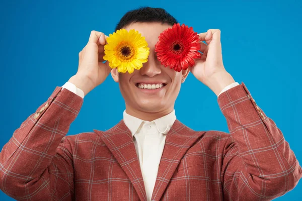 Glad Upphetsad Ung Man Täcker Ögonen Med Ljusa Blommande Blommor — Stockfoto