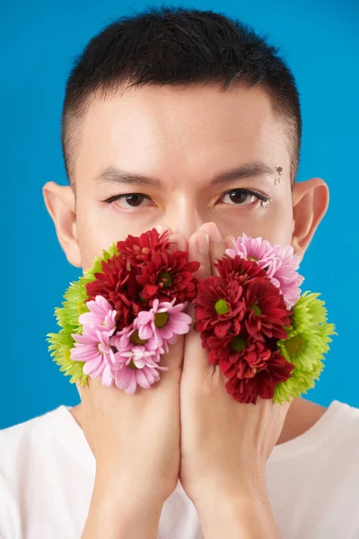 Portrait Serious Young Man Holding Bright Blooming Flowers Covering Mouth — Stock Photo, Image
