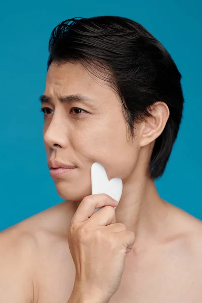 Hombre Masajeando Cara Con Gua Sha Para Prevenir Arrugas —  Fotos de Stock
