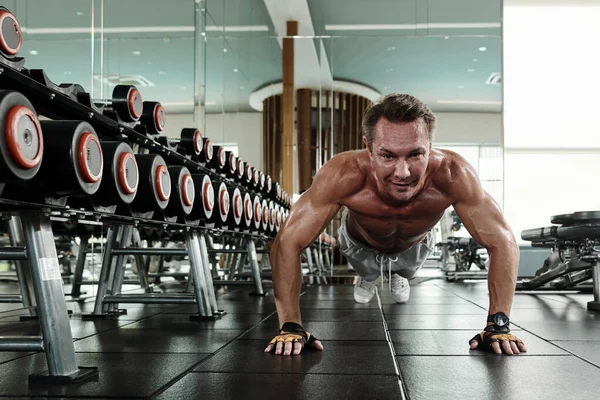 强壮健康的男人在做胸肌运动时 会在健身房地板上做俯卧撑 — 图库照片