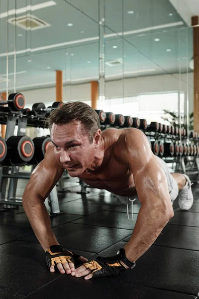 适合强壮的男人早上锻炼时在健身房里做俯卧撑 — 图库照片