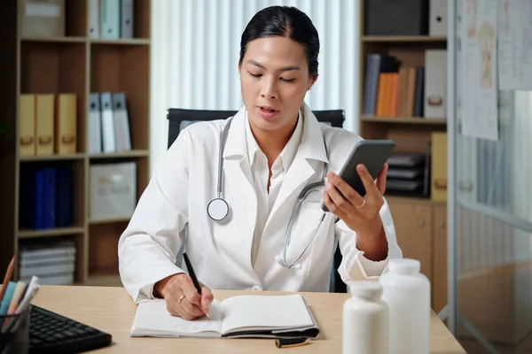 Doktor Hastanın Sesli Mesajını Dinliyor Tavsiye Mektuplarını Yazıyor — Stok fotoğraf