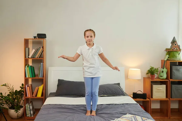 Радостная Девушка Прыгает Кровати Веселится Дома После Школы — стоковое фото