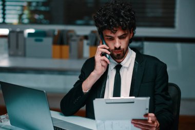 İş adamı rapor detaylarını iş arkadaşı ve son teslim tarihi kavramı ile tartışmak için telefon görüşmesi yapıyor.
