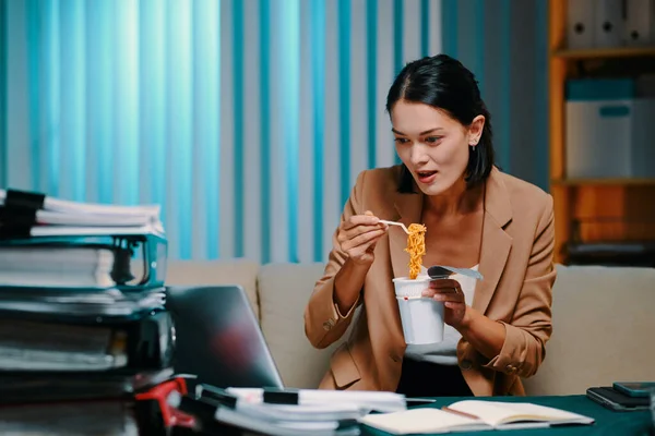 Πεινασμένη Επιχειρηματίας Τρώει Στιγμιαία Noodle Όταν Παρακολουθείτε Παρουσίαση Στο Φορητό — Φωτογραφία Αρχείου