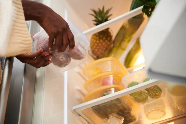 女人把装有新鲜水果的容器放在冰箱里 — 图库照片