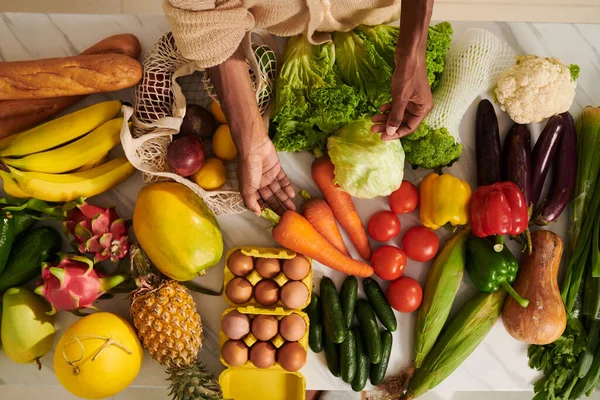 ブラック女性の前でキッチンテーブルの上に新鮮な野菜 — ストック写真