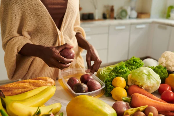 女人把蔬菜和水果放在塑料容器里放在冰箱里 — 图库照片