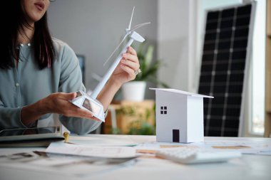 Sürdürülebilir enerji şirketi yöneticisi toplantıda müşteri sunmak için model oluşturuyor