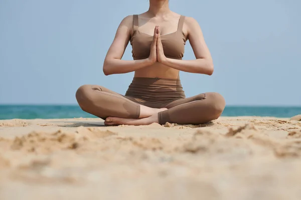 Spor Sutyenli Taytlı Genç Bir Kadının Sahilde Meditasyon Yaparken Görüntüsü — Stok fotoğraf