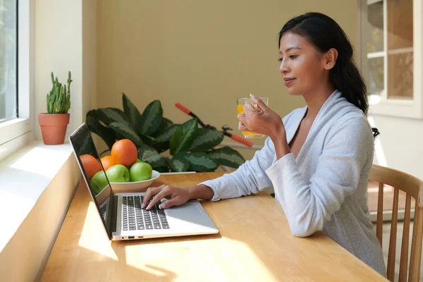 Mujer Joven Positiva Beber Taza Jugo Frutas Trabajar Ordenador Portátil —  Fotos de Stock