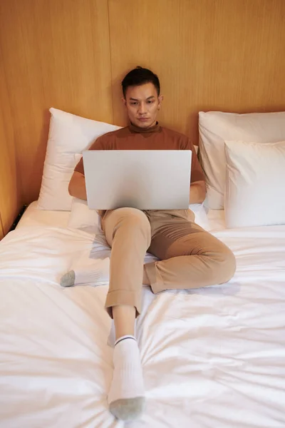 Sério Asiático Jovem Sentado Cama Codificação Laptop — Fotografia de Stock