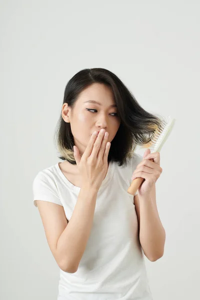 Saçına Takılmış Fırçaya Bakarken Ağzını Kapatan Genç Asyalı Kadın — Stok fotoğraf