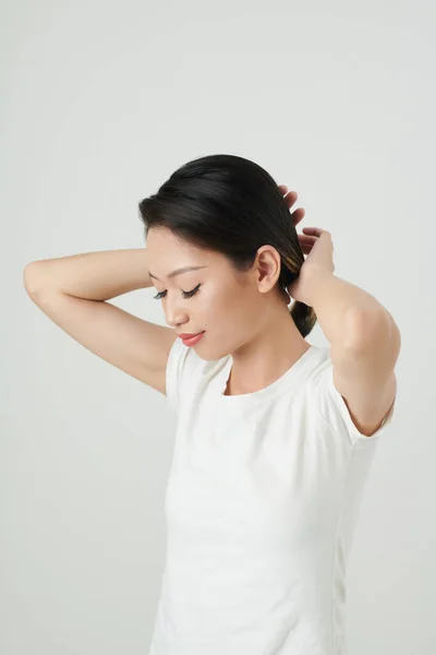 笑顔若いですアジアの女性でホワイトTシャツ作りPonytail — ストック写真