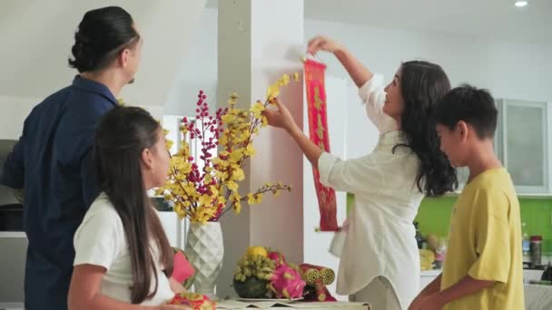 Família Asiática Feliz Decorar Casa Com Decoração Tet Tradicional Parede — Vídeo de Stock