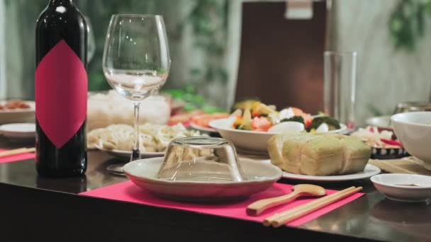 伝統的なベトナム料理とワインのボトルの中間ショット休日のディナーテーブルには人がいません — ストック動画