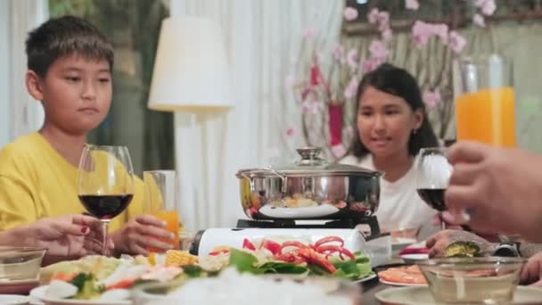 亚洲家庭一边坐在餐桌旁一边烧烤一边喝酒 在家里庆祝农历新年 — 图库视频影像