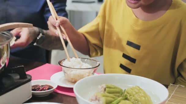 Przycięty Strzał Małego Azjatyckiego Chłopca Jedzącego Ryż Pałeczkami Przy Stole — Wideo stockowe