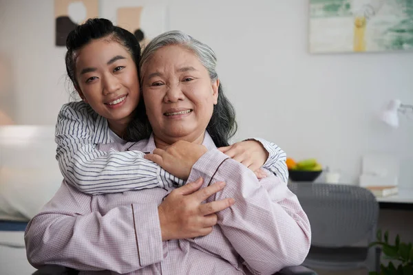 Fröhliche Junge Frau Umarmt Großmutter Bei Besuch Pflegeheim — Stockfoto