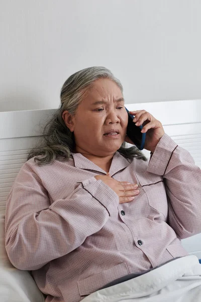 Starostlivá Starší Žena Bavlněném Pyžamu Sedí Posteli Volá Doktora Stěžuje — Stock fotografie