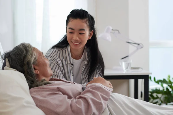 Gülümseyen Genç Kadın Hasta Olan Yaşlı Annesini Yanına Alıyor Yatakta — Stok fotoğraf
