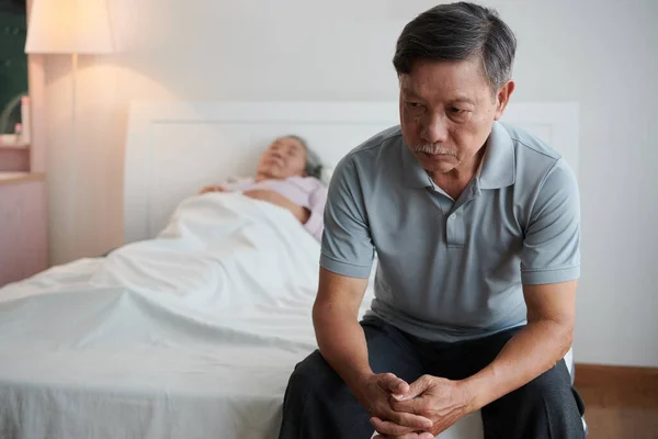 Bunalıma Girmiş Yaşlı Bir Adam Hasta Karısının Yatağında Oturuyor — Stok fotoğraf