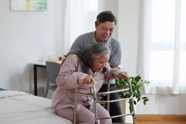 Ηλικιωμένη Γυναίκα Που Προσπαθεί Σηκωθεί Από Κρεβάτι Ακουμπισμένη Στον Γουόκερ — Φωτογραφία Αρχείου