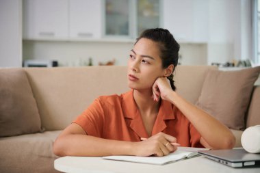 Düşünceli genç bir kadının portresi Düşüncelerini ve fikirlerini planlayıcıyla yazıyor