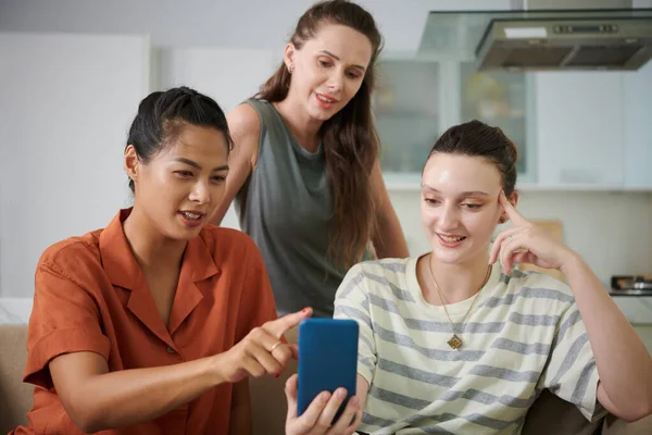 Lächelnde Junge Frau Zeigt Freunden Neue Anwendung Auf Dem Smartphone — Stockfoto