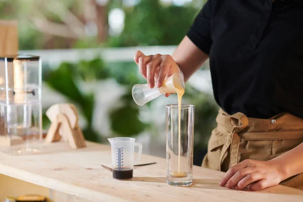 在制作冷咖啡饮料时 巴里斯塔将浓缩牛奶倒入高杯中 — 图库照片