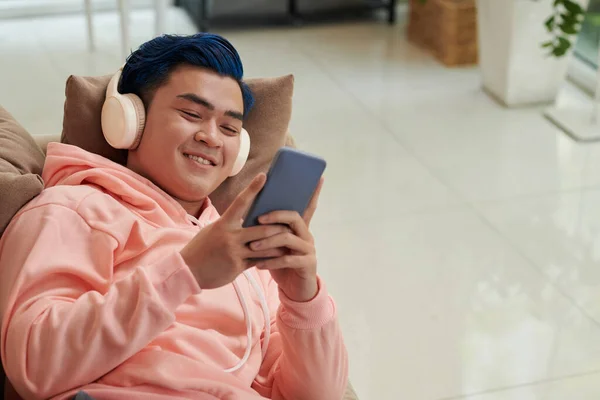 Veselý Mladý Muž Relaxovat Gauči Hrát Hru Smartphone — Stock fotografie