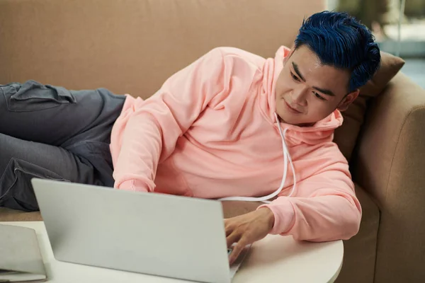 Jovem Preguiçoso Deitado Sofá Tentando Codificar Laptop — Fotografia de Stock