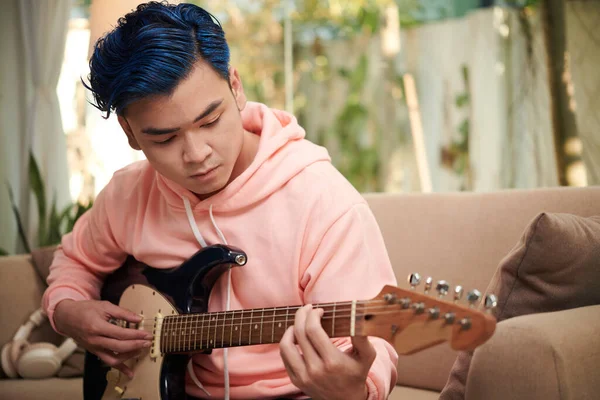集中創造的な若いです男とともに青い髪遊びギターTa家 — ストック写真