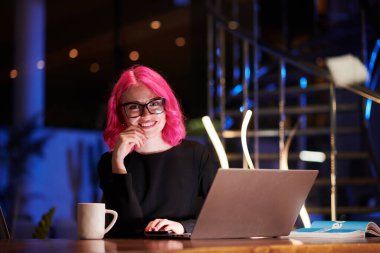 Gülümseyen gece kulübü sahibi barda dizüstü bilgisayarla çalışıyor.