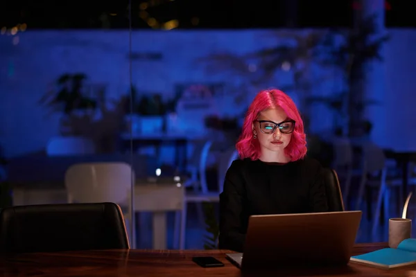 Молодая Женщина Горячими Розовыми Волосами Работает Ноутбуке Темном Кафе — стоковое фото