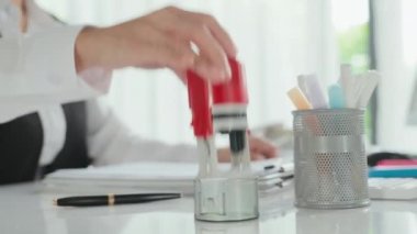 Tanımlanamayan kadın sigortacının müşteriyle anlaşma yaptıktan sonra belgeye damga vurması.