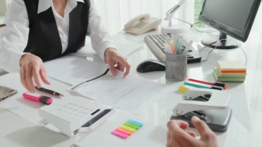 Tanımlanamayan kadın banka temsilcisinin modern ofisindeki müşterisine danışarak sigorta sözleşmesindeki çizgileri vurgulaması.