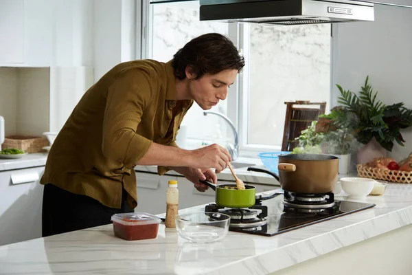 Young Man Enjoying Cooking Dinner Home Stirring Mashed Potatoes Saucepan — Stock Photo, Image