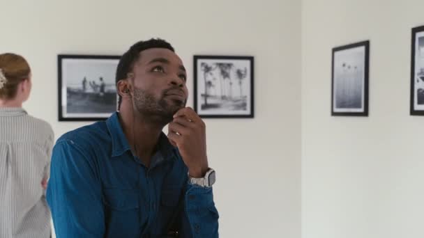 Giovane Uomo Afroamericano Che Ascolta Audioguida Con Auricolari Guarda Mostra — Video Stock