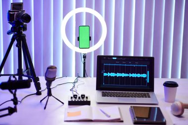 Blogger stüdyosunda dizüstü bilgisayarlı, planlı ve çekim ekipmanlı bir masa