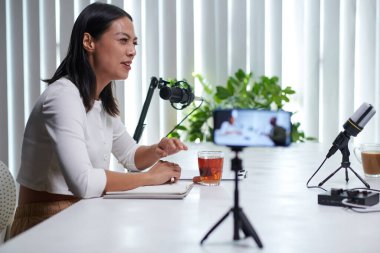 Gülümseyen kadın konuklarla sabah podcast 'i yapıyor.