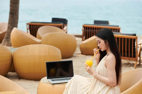 Young Woman Sipping Fruit Cocktail Watching Entertaining Educational Video Laptop — Stock Photo, Image