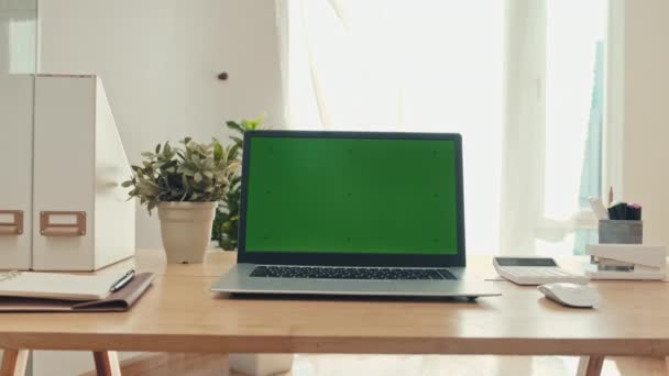办公室里没有人 桌上放着装有绿色彩色按键屏幕的中档笔记本电脑 — 图库视频影像