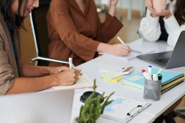 Fiatal Üzletasszonyok Közelről Jegyzetelnek Dokumentumokban Miközben Együtt Dolgoznak Asztalnál Irodában — Stock Fotó