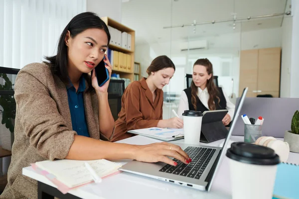 Junge Geschäftsfrau Telefoniert Und Tippt Auf Laptop Mit Ihren Kollegen — Stockfoto