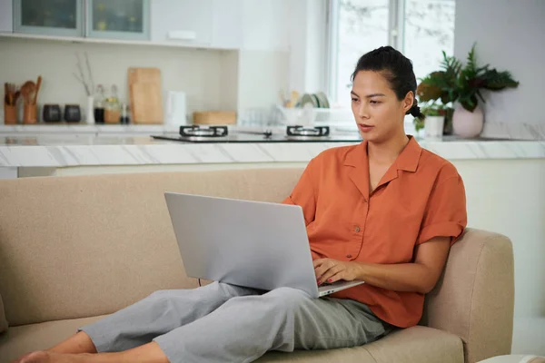 Jonge Vrouw Liggend Bank Typen Laptop Tijdens Haar Vrije Tijd — Stockfoto