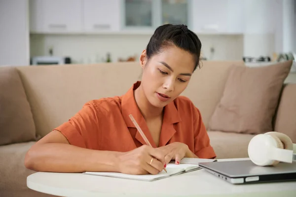Mujer Joven Haciendo Notas Copybook Sentado Mesa Con Ordenador Portátil —  Fotos de Stock