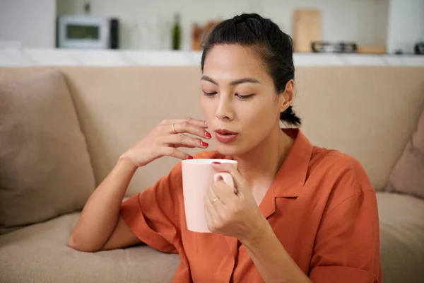 Junge Frau Bläst Auf Tasse Und Trinkt Heißen Kaffee Während — Stockfoto