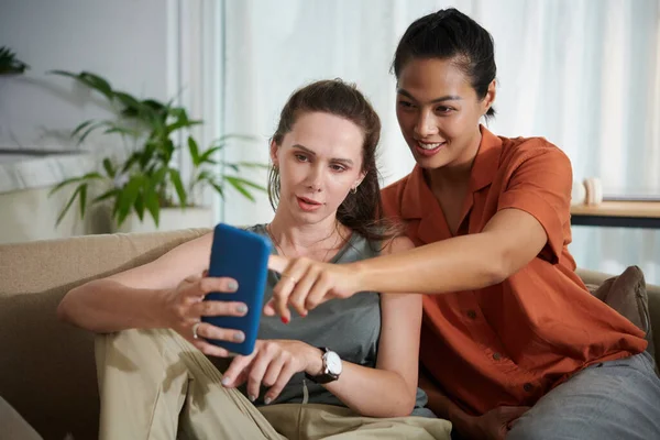 Due Amici Che Usano Smartphone Insieme Seduti Sul Divano Casa — Foto Stock