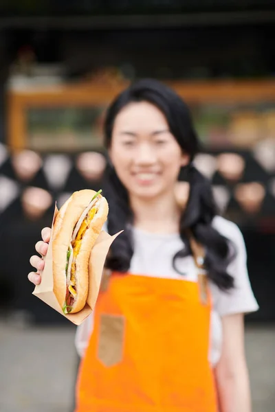 Focus Fresh Appetizing Hotdog Paper Held Young Asian Female Vendor — Stock Photo, Image